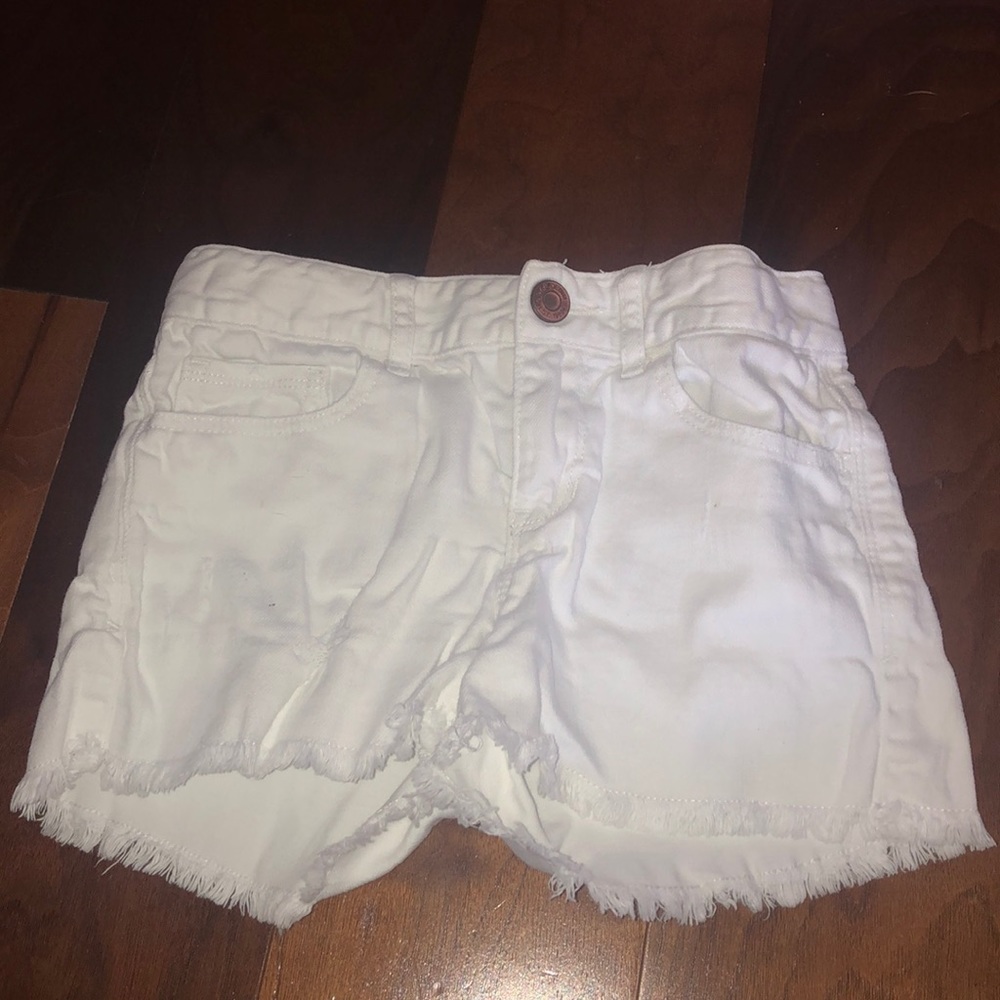 White kids short shorts with distressed bottoms.